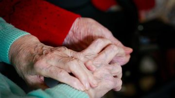 Una pareja de ancianos se da la mano