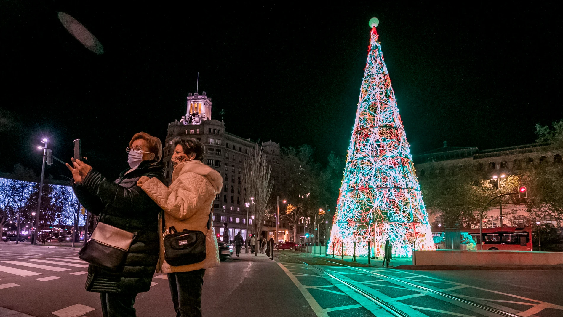Unas mujeres se fotografían con el árbol de Navidad en la Plaza de Paraíso de Zaragoza