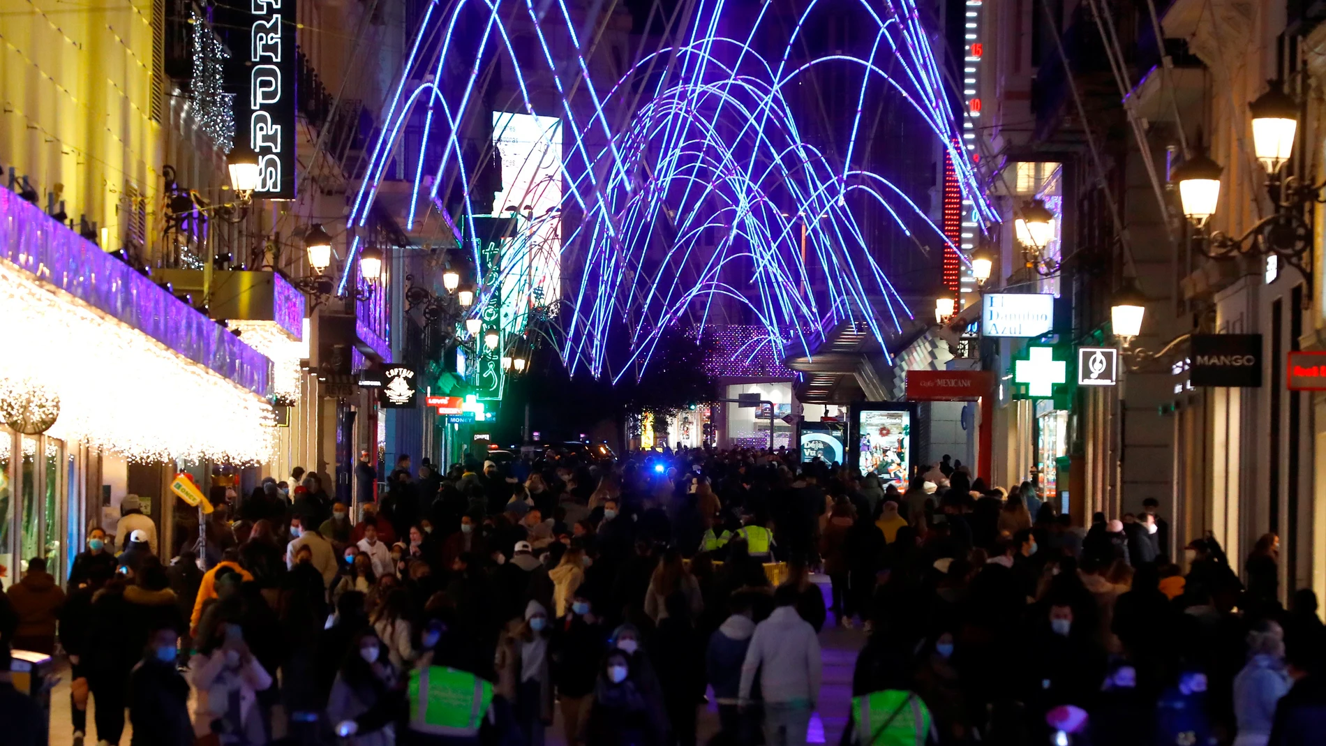 Personas se congregan para disfrutar de las luces navideñas en la calle de Preciados, este martes en Madrid.