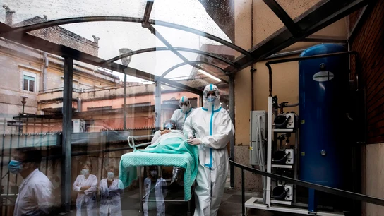 Sanitarios acompañan a una enferma de COVID Sanitarios acompañan a una enferma de COVID