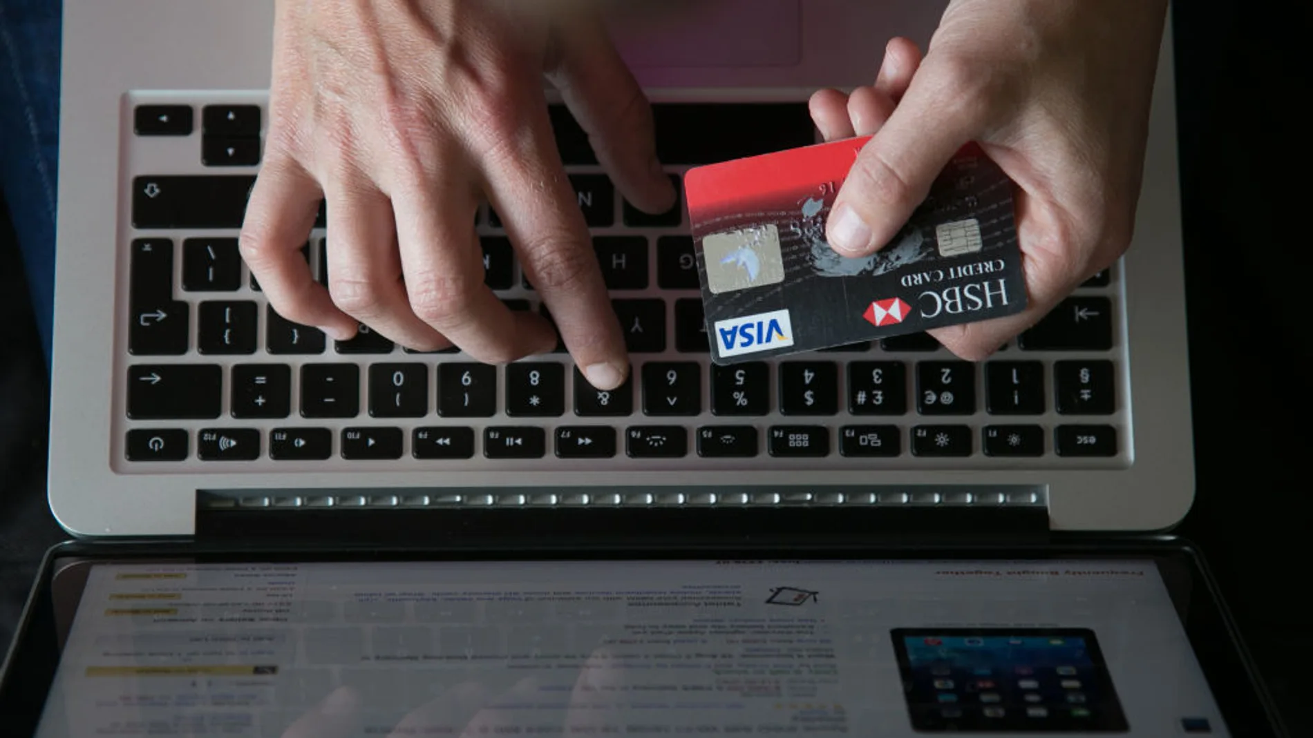 Una persona utiliza su tarjeta de crédito para pagar una compra online