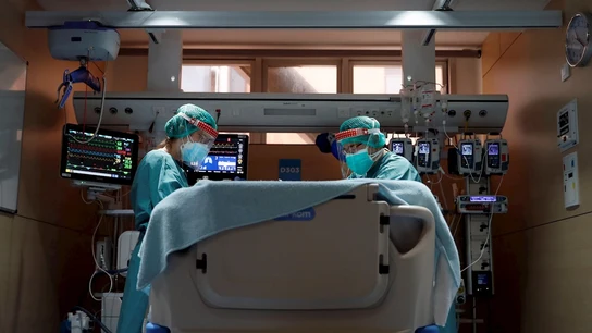 Dos médicos atienden a un paciente con coronavirus en un hospital. Dos médicos atienden a un paciente con coronavirus en un hospital