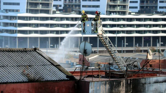 Bomberos en labores de extinción en la nave incendiada en Badalona.