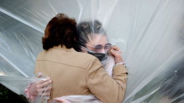 Una mujer abraza a su abuela durante la pandemia de coronavirus