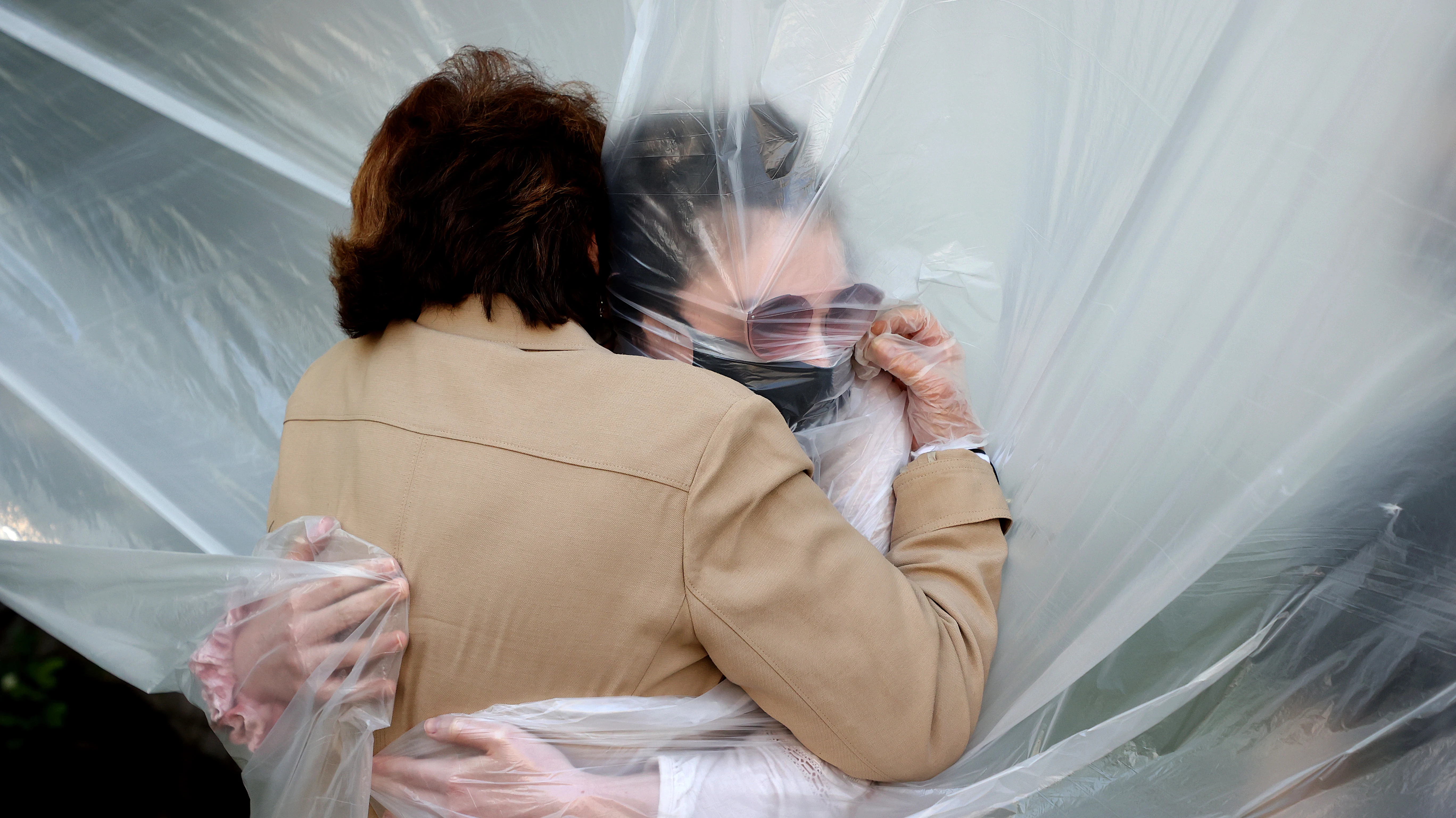 Una mujer abraza a su abuela durante la pandemia de coronavirus