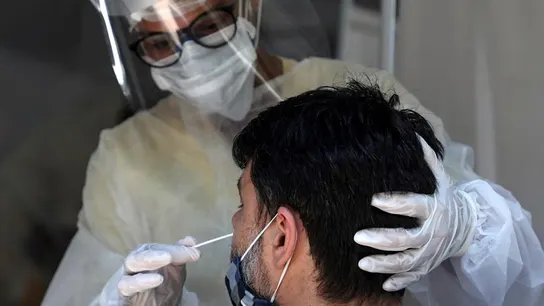 Una sanitaria realiza una prueba diagnóstica a un paciente. Una sanitaria realiza una prueba diagnóstica a un paciente.