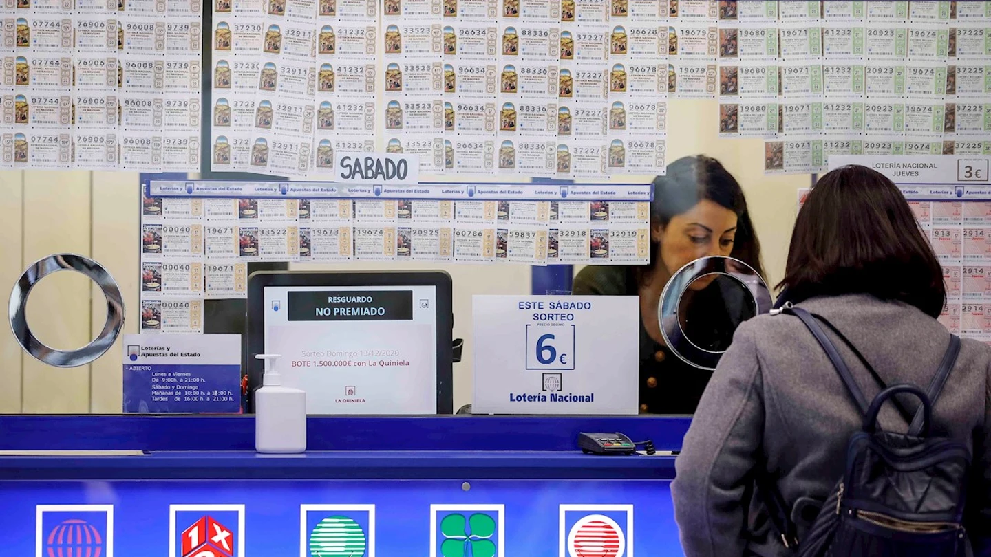 Una persona adquiere lotería en una administración Una persona adquiere lotería en una administración