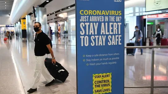 Un viajero con mascarilla en un aeropuerto de Reino Unido Un viajero con mascarilla en un aeropuerto de Reino Unido
