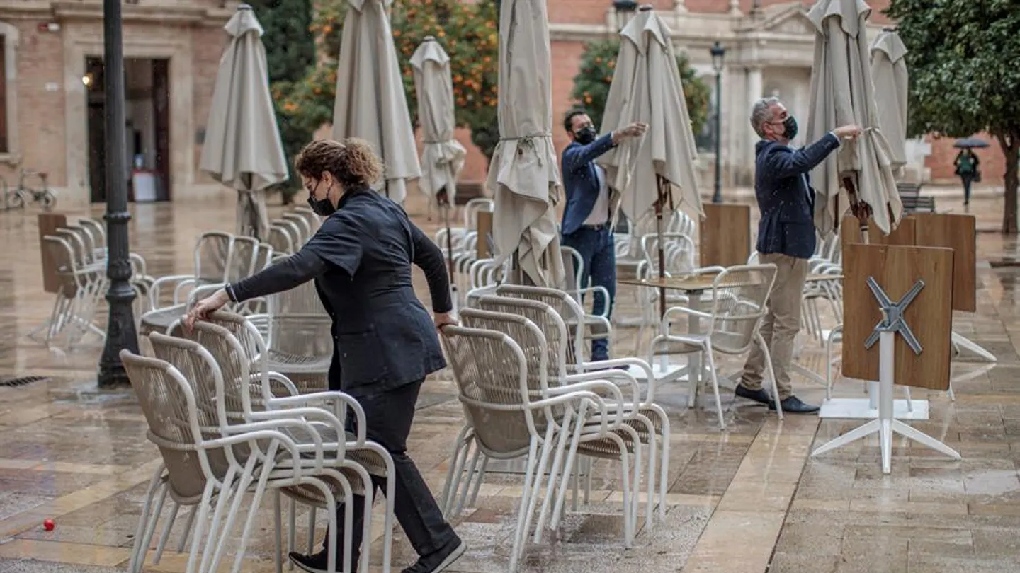 Trabajadores de un restaurante valenciano recogen la terraza de su establecimiento Trabajadores de un restaurante valenciano recogen la terraza de su establecimiento