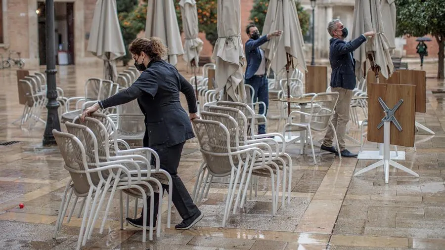 Trabajadores de un restaurante valenciano recogen la terraza de su establecimiento