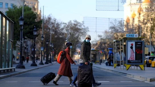 Una pareja pasea portando sus maletas Una pareja pasea portando sus maletas