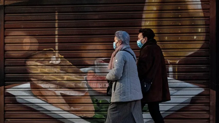 Personas caminan frente a un establecimiento cerrado