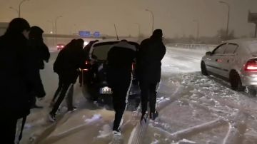 Jugadores del Rayo ayudando a un coche en la nieve