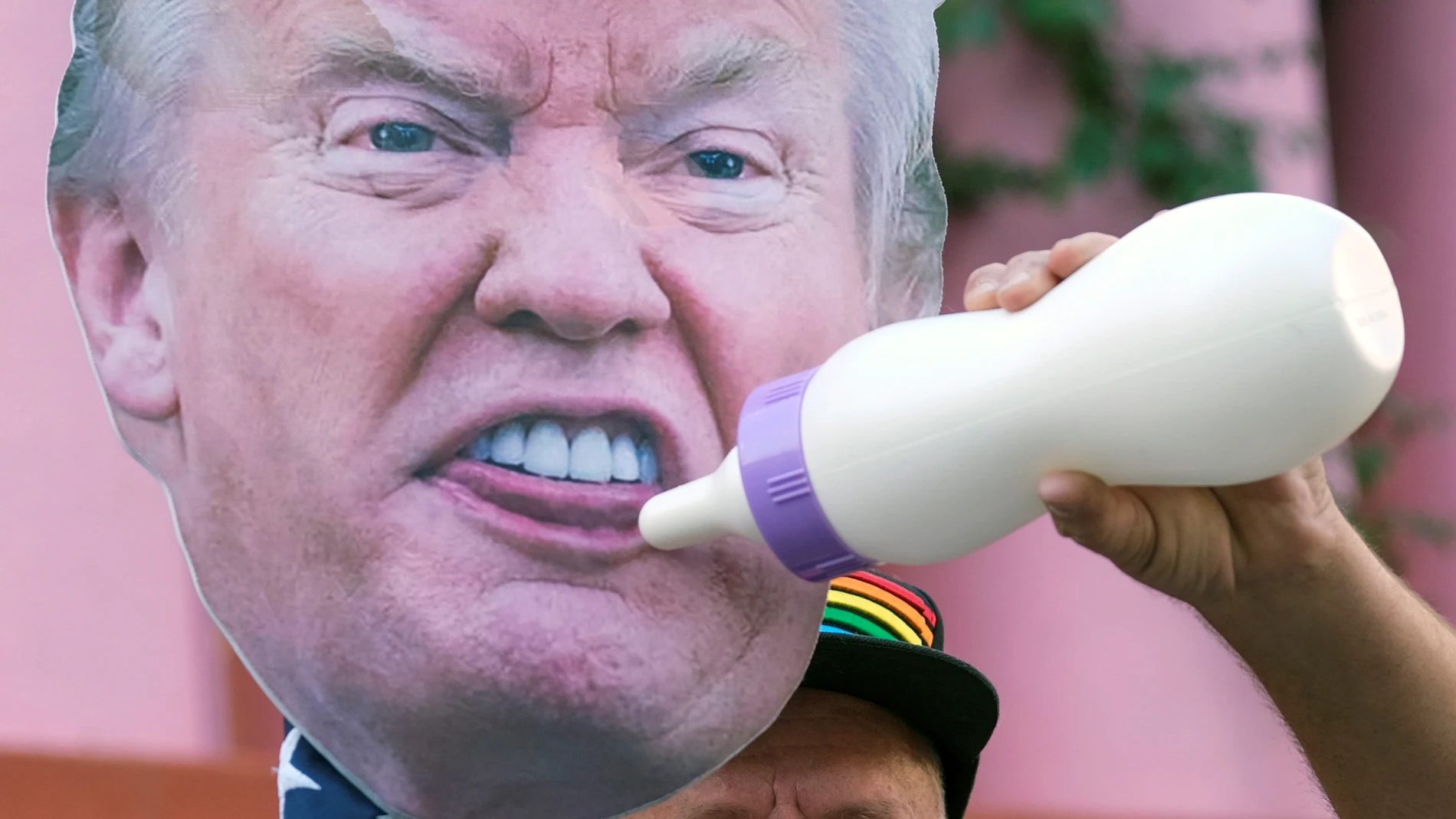 Un manifestante porta una careta de Trump con un biberón
