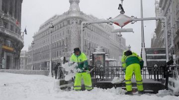 Operarios quitan la nieve en las cercanías a la Puerta del Sol de Madrid