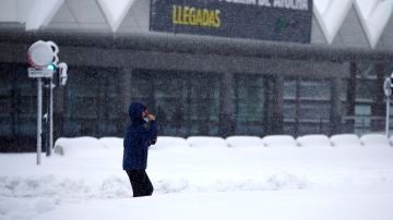 Un hombre espera en la estación de Atocha bajo la nieve