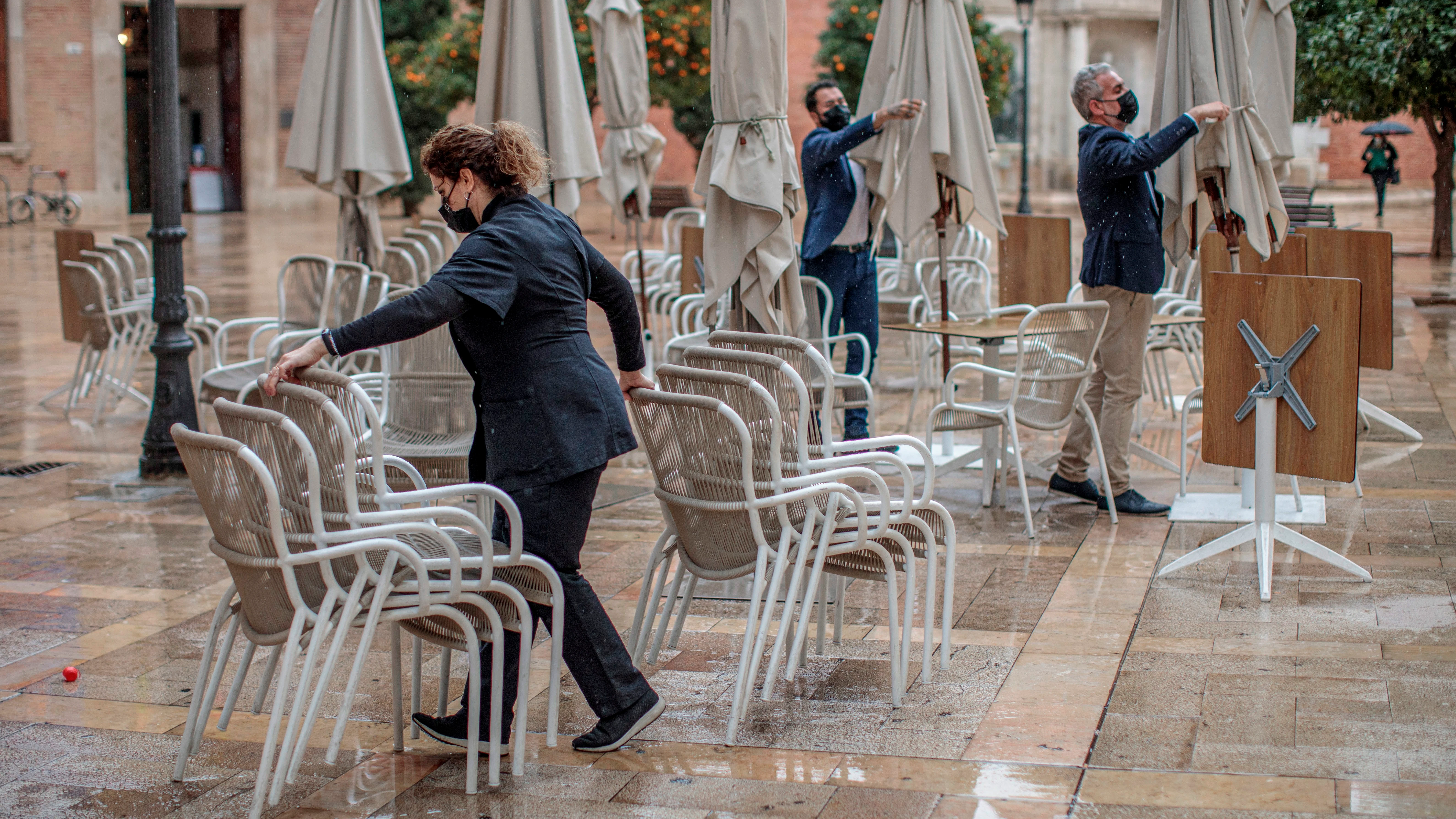 Unos trabajadores de un restaurante del centro de Valencia recogen la terraza.