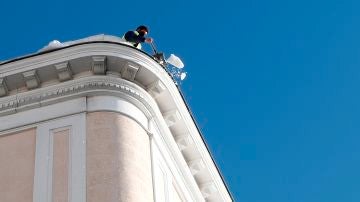 Un operario retira nieve del techo de una vivienda este lunes en Madrid