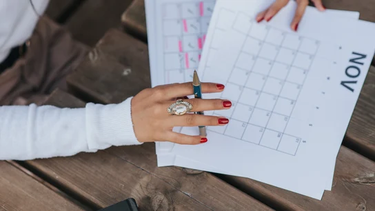 Calendario laboral de 2021: estos son los puentes que tendremos este año Mujer ojea las diferentes páginas de un calendario