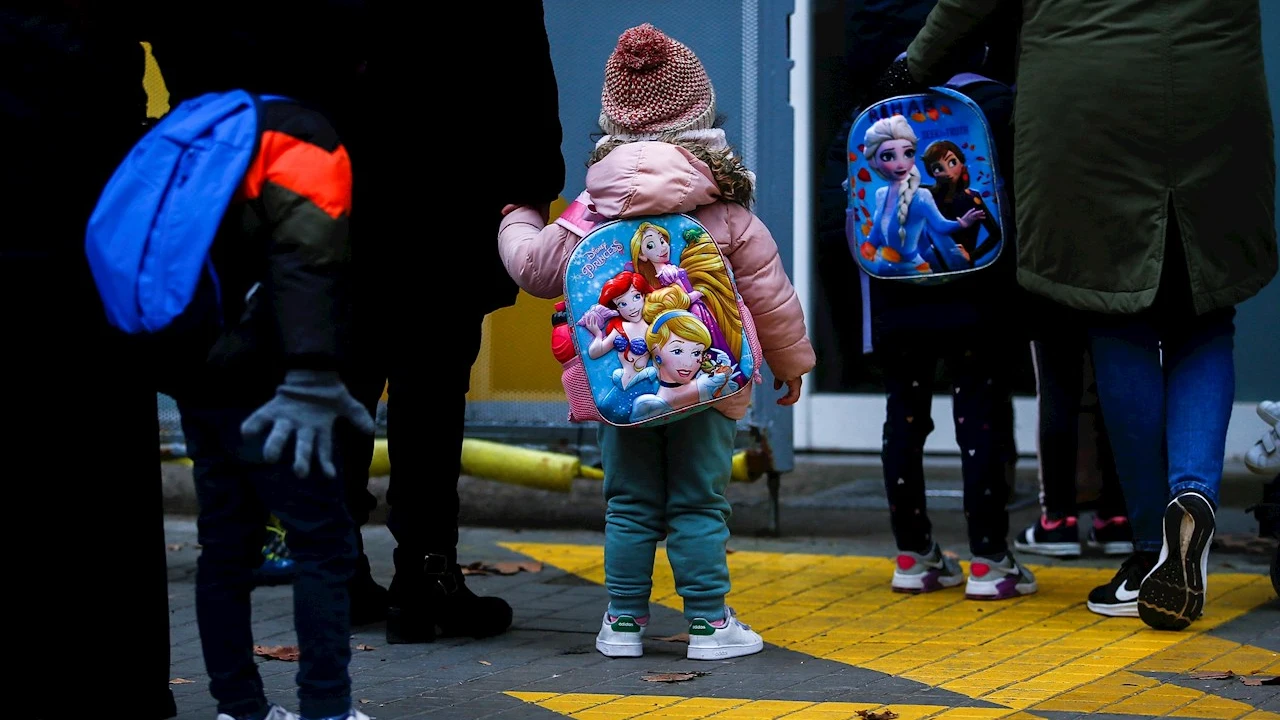 Niños esperan para entrar en un colegio