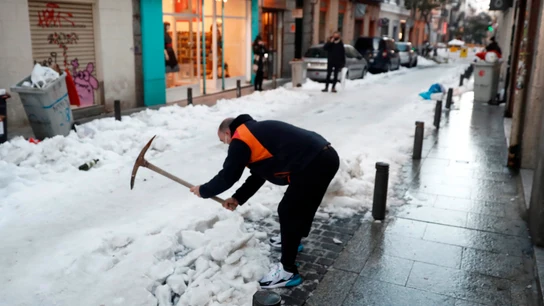 Un vecino retira nieve de la calzada en calle León de Madrid.  Un vecino retira nieve de la calzada en calle León de Madrid.