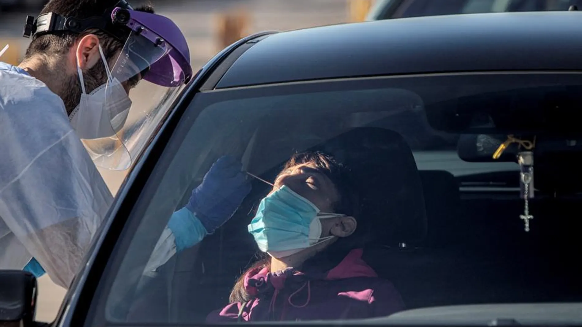 Un sanitario realiza test para detectar la covid-19 a pacientes en sus vehículos frente al hospital de campaña de La Fe de Valencia.