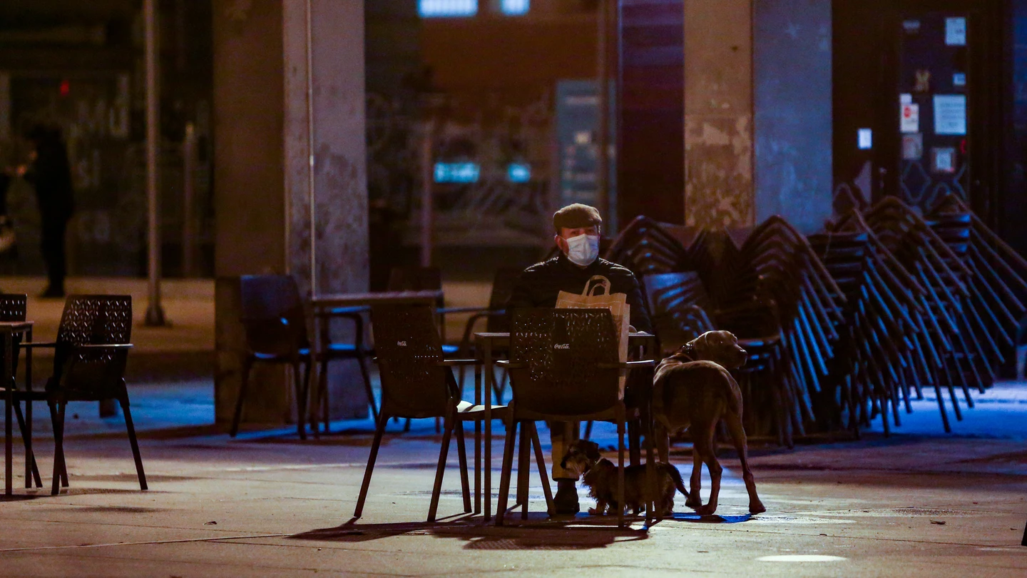 Un hombre con sus dos perros sentado en la terraza de un bar de Madrid Restricciones coronavirus
