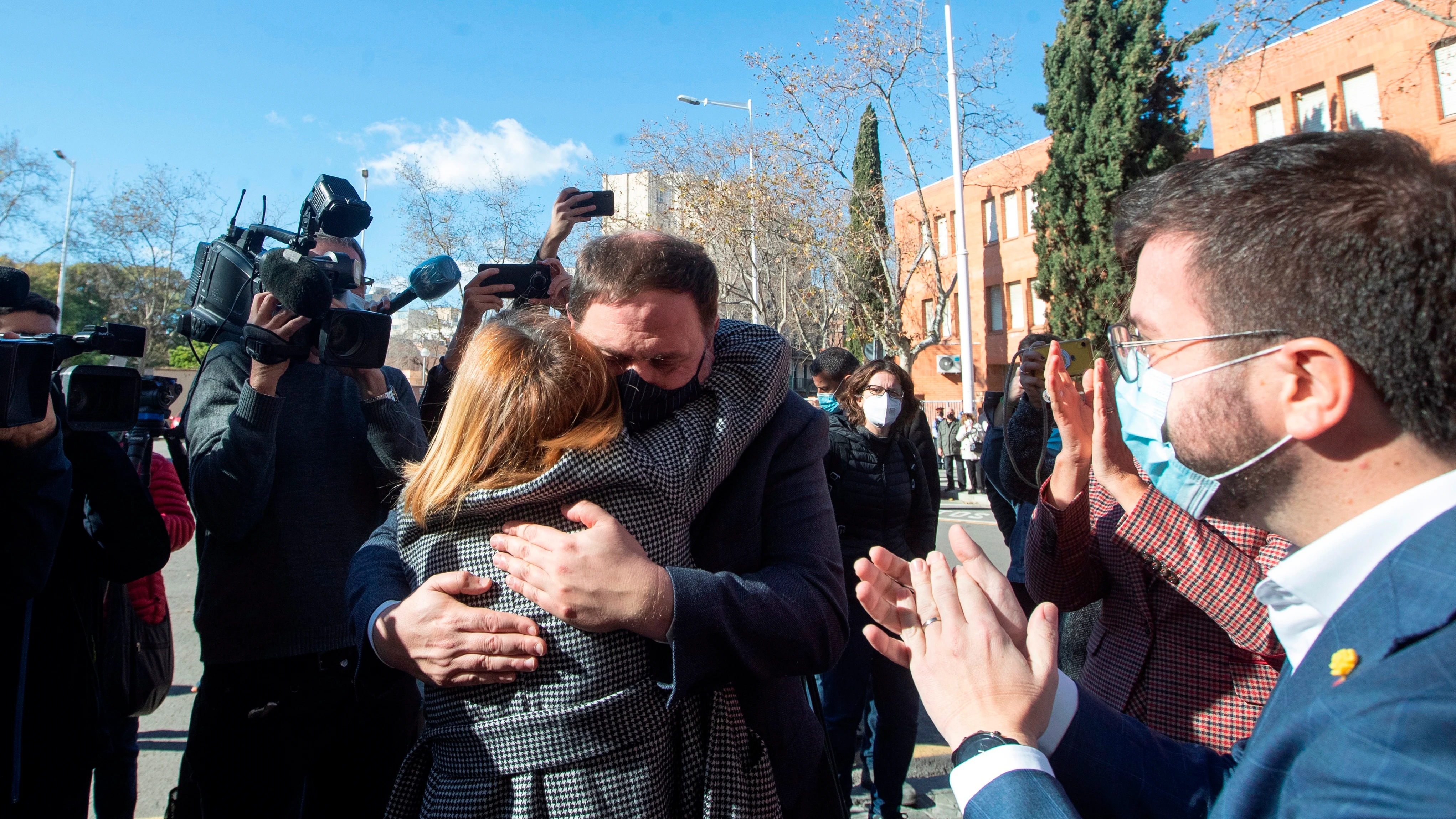 La expresidenta del Parlament, Carme Forcadell, se abraza con Oriol Junqueras ante la presencia del candidato de ERC a la Generalitat, Pere Aragonés