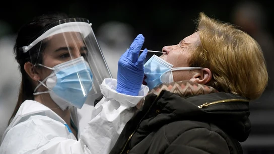 Imagen de una sanitaria realizando una PCR a una mujer Imagen de una sanitaria realizando una PCR a una mujer
