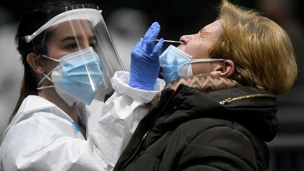 Imagen de una sanitaria realizando una PCR a una mujer