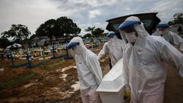 Trabajadores entierran a una persona fallecida por coronavirus en el cementerio público Nossa Senhora Aparecida en Manaos, Amazonas.