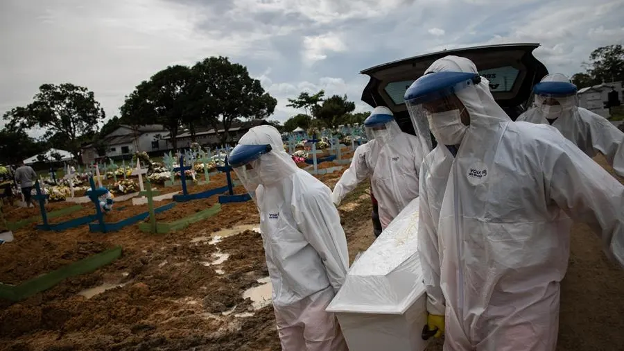 Trabajadores entierran a una persona fallecida por coronavirus en el cementerio público Nossa Senhora Aparecida en Manaos, Amazonas.