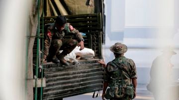 Soldados militares trasladan bolsas de un camión al Ayuntamiento de Yangon, en Birmania