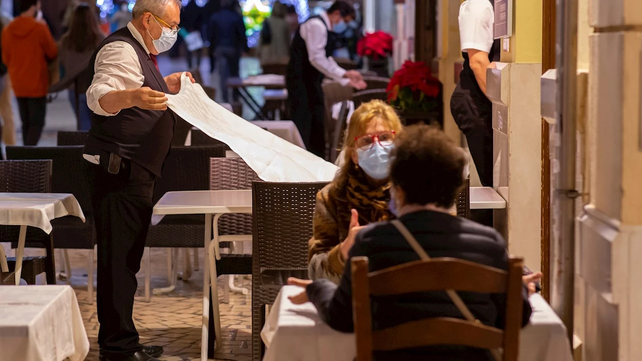 Varias personas con mascarilla en una terraza de Málaga