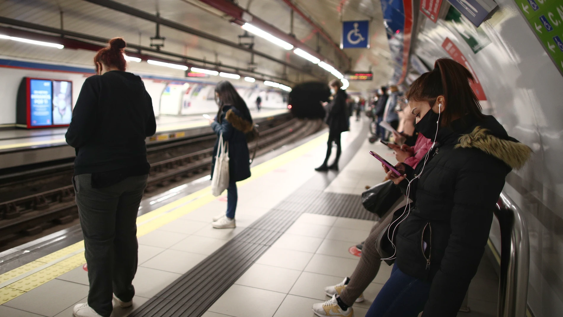 Varios pasajeros esperan en un andén de metro de la estación de Sol