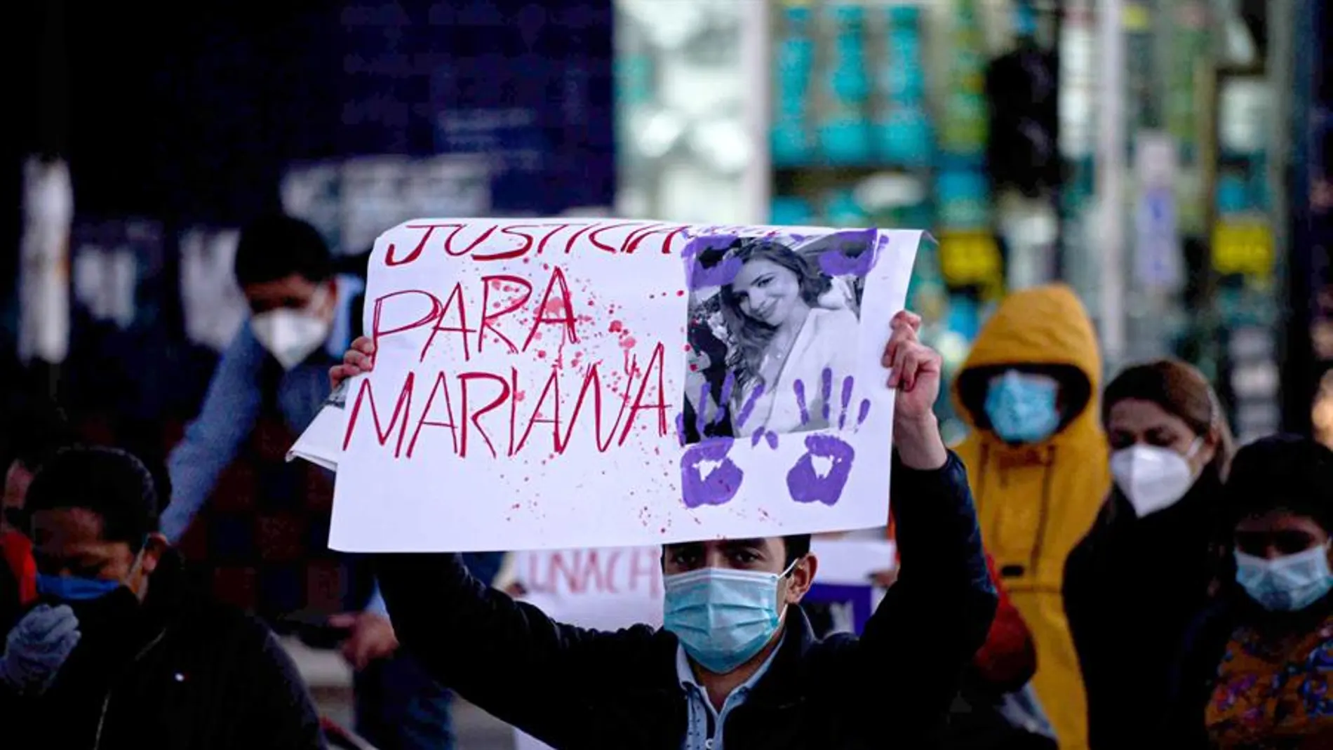 Un hombre sostiene un cartel de protesta durante una movilización para rechazar el feminicidio de una médica.
