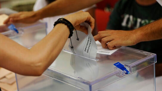 Una persona deposita su voto en una urna