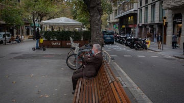 Un hombre descansa en un banco durante el cuarto día de la entrada en vigor de las nuevas restricciones en Cataluña