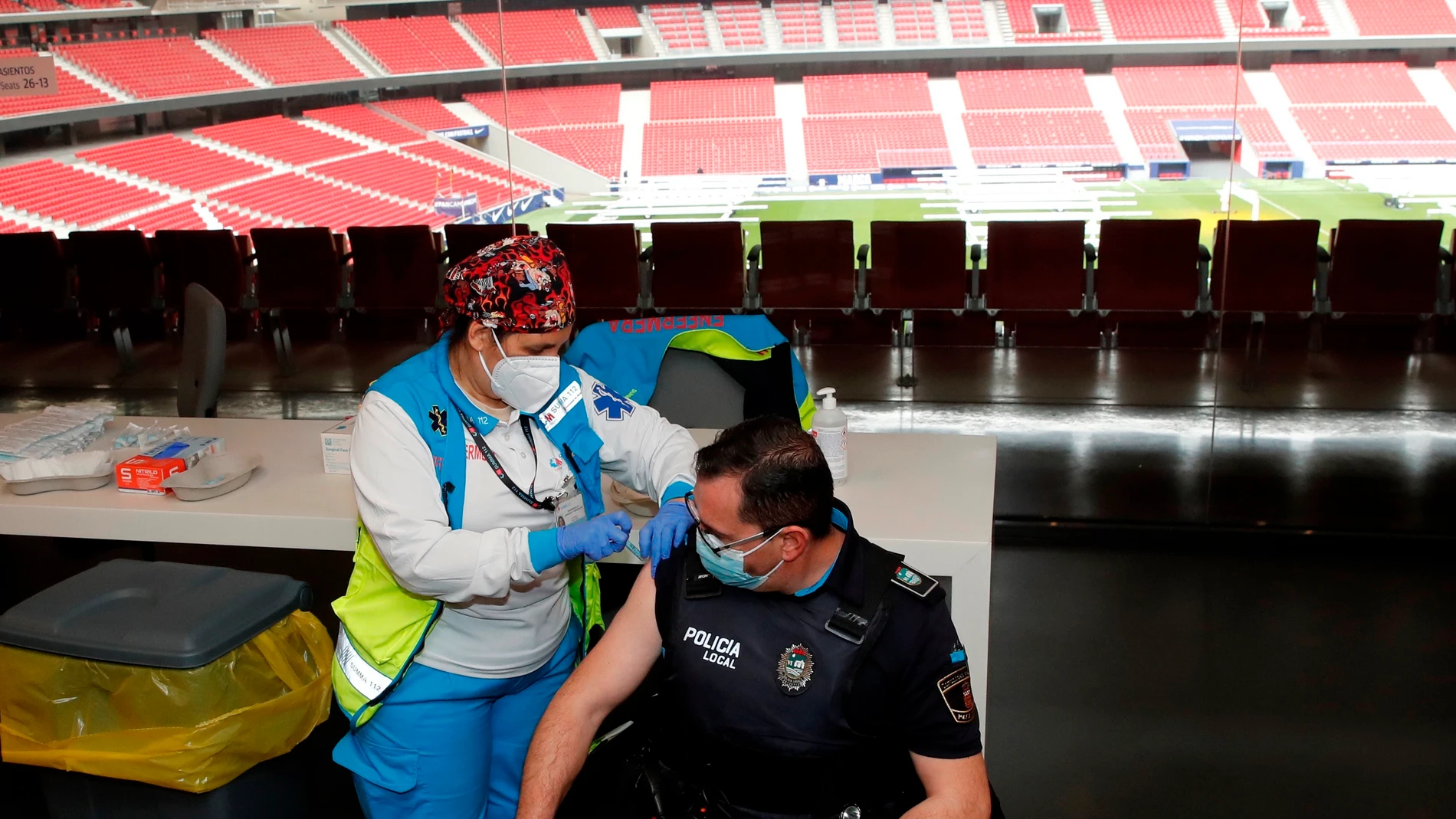 Un policía recibe la primera dosis durante el primer día de vacunación contra la covid-19 en el Wanda Metropolitano