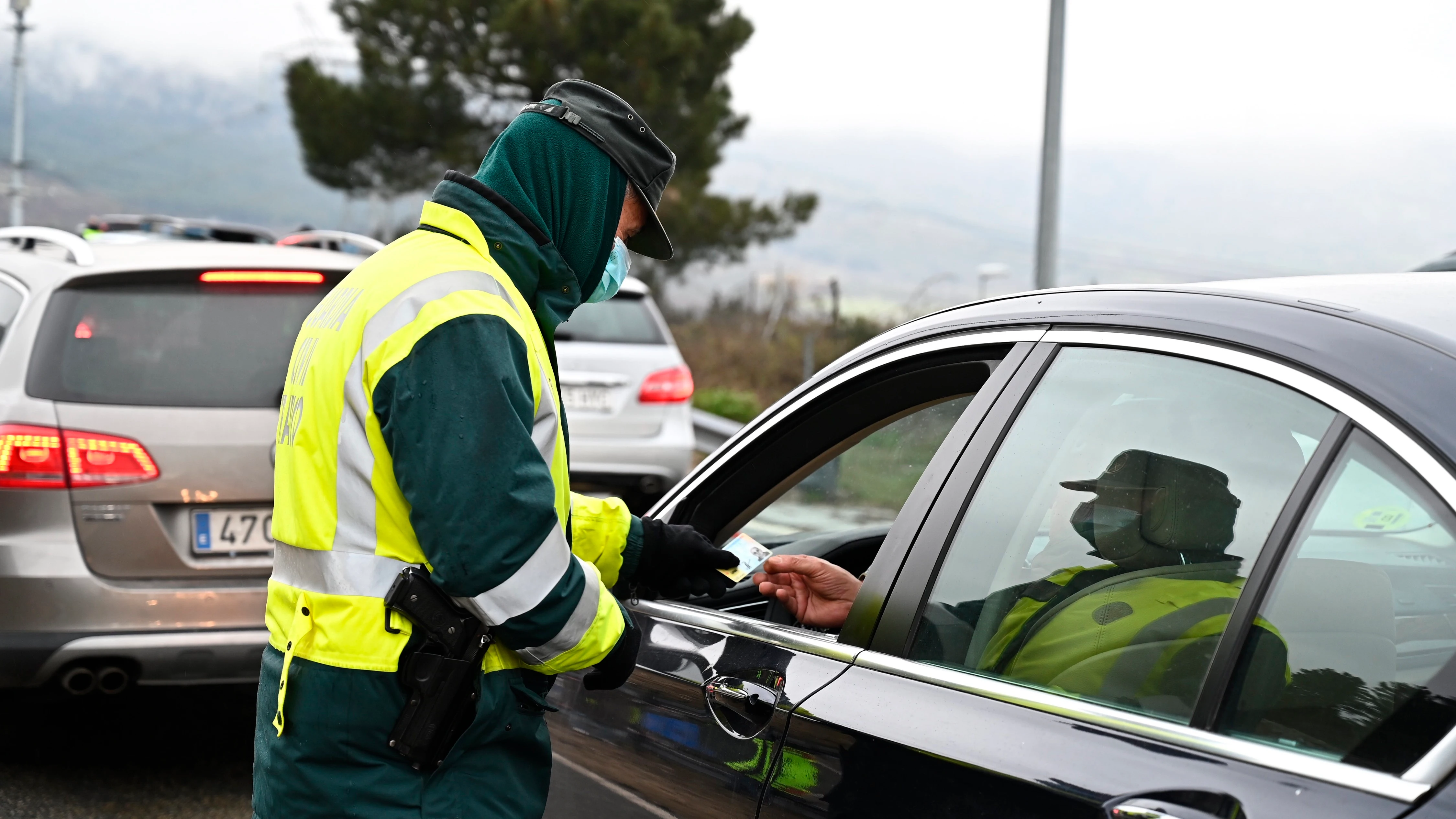 Un guardia civil pide la documentación a un conductor en un control de carretera a la altura de Guadarrama (Madrid)