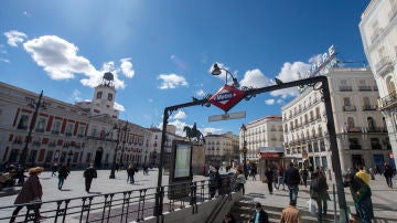 Ciudadanos caminan por la Puerta del Sol, en Madrid
