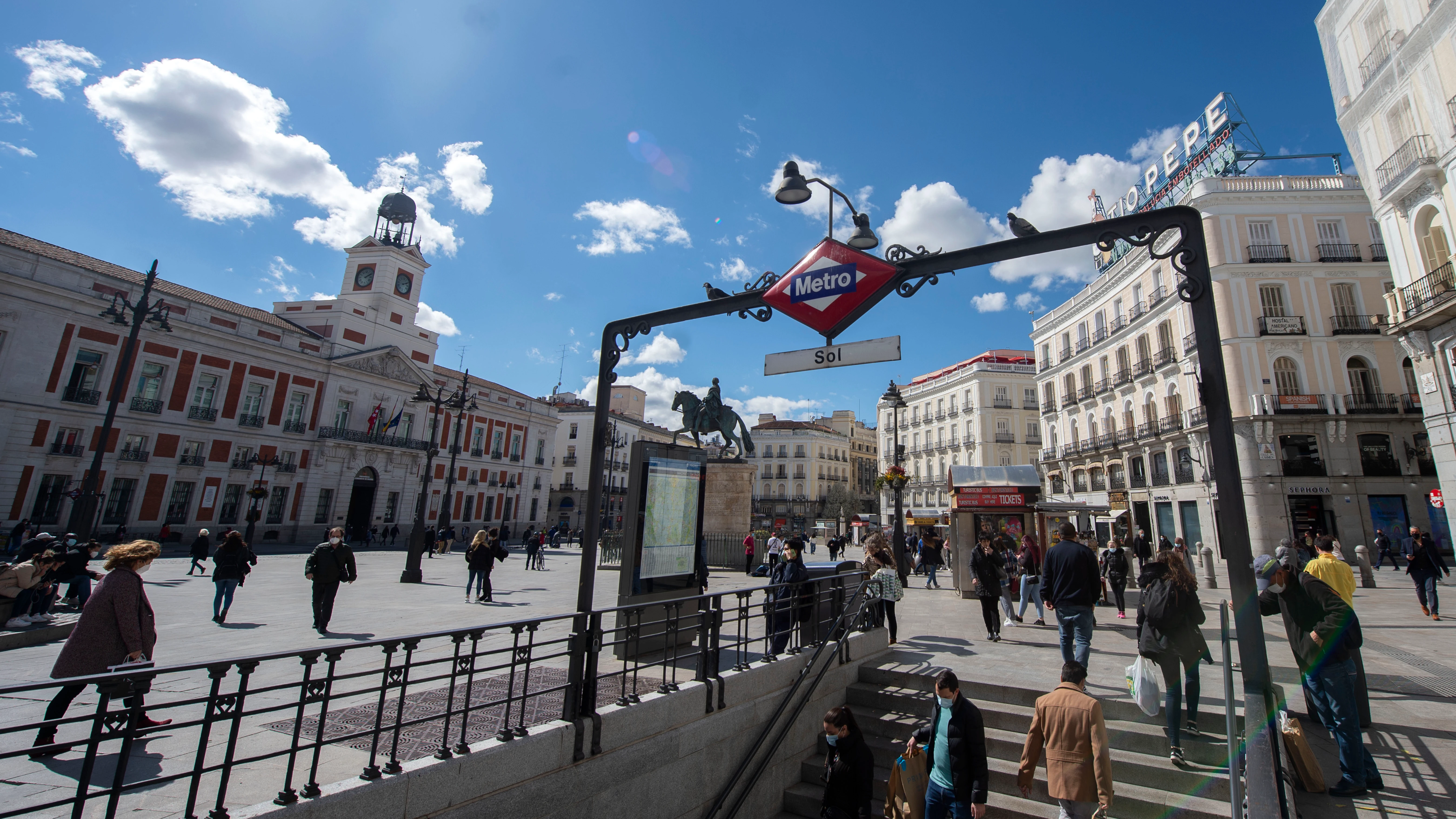 Ciudadanos caminan por la Puerta del Sol, en Madrid