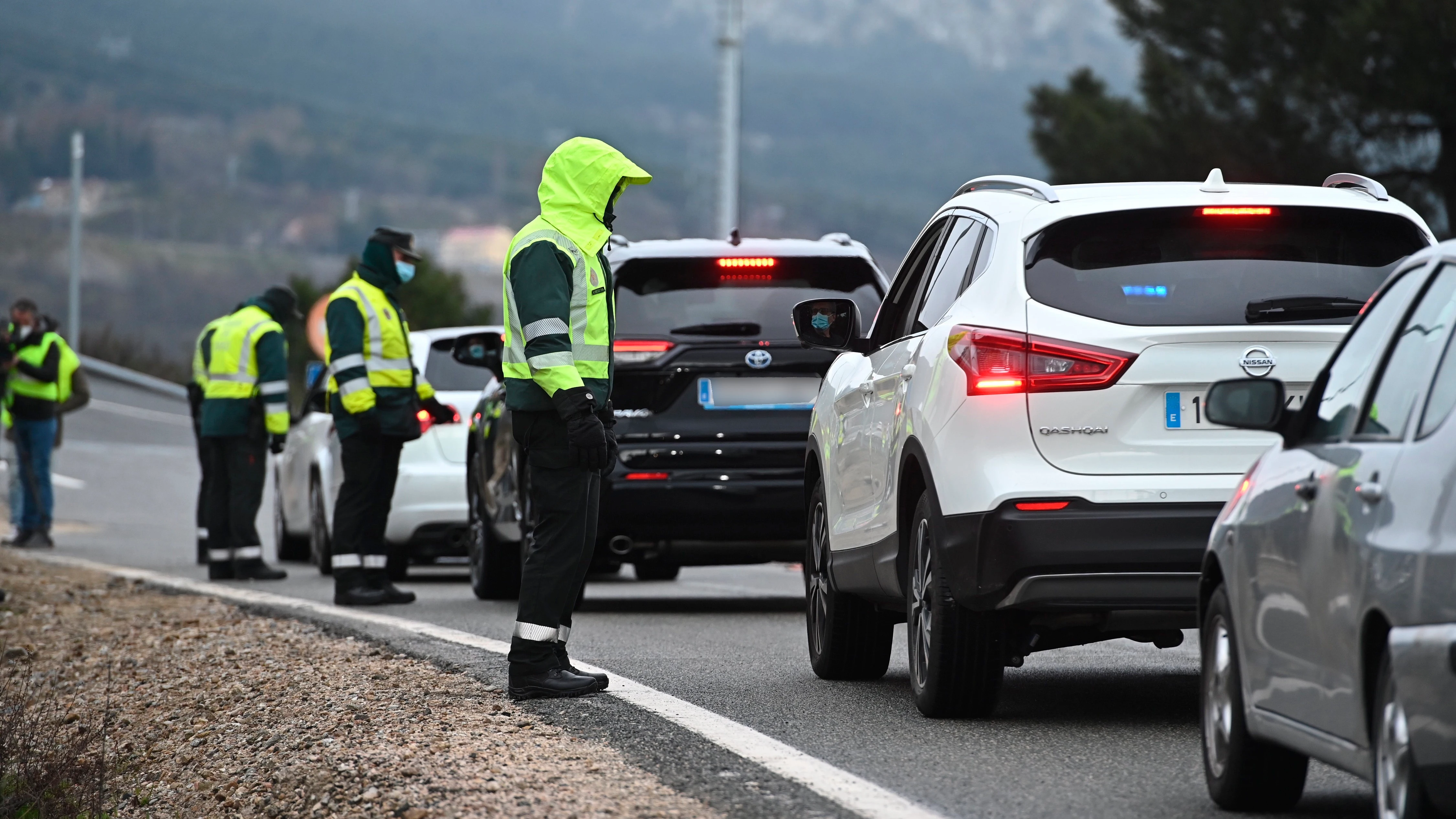 Varios guardias civiles de tráfico realizan un control de carretera debido a las restricciones por la pandemia 