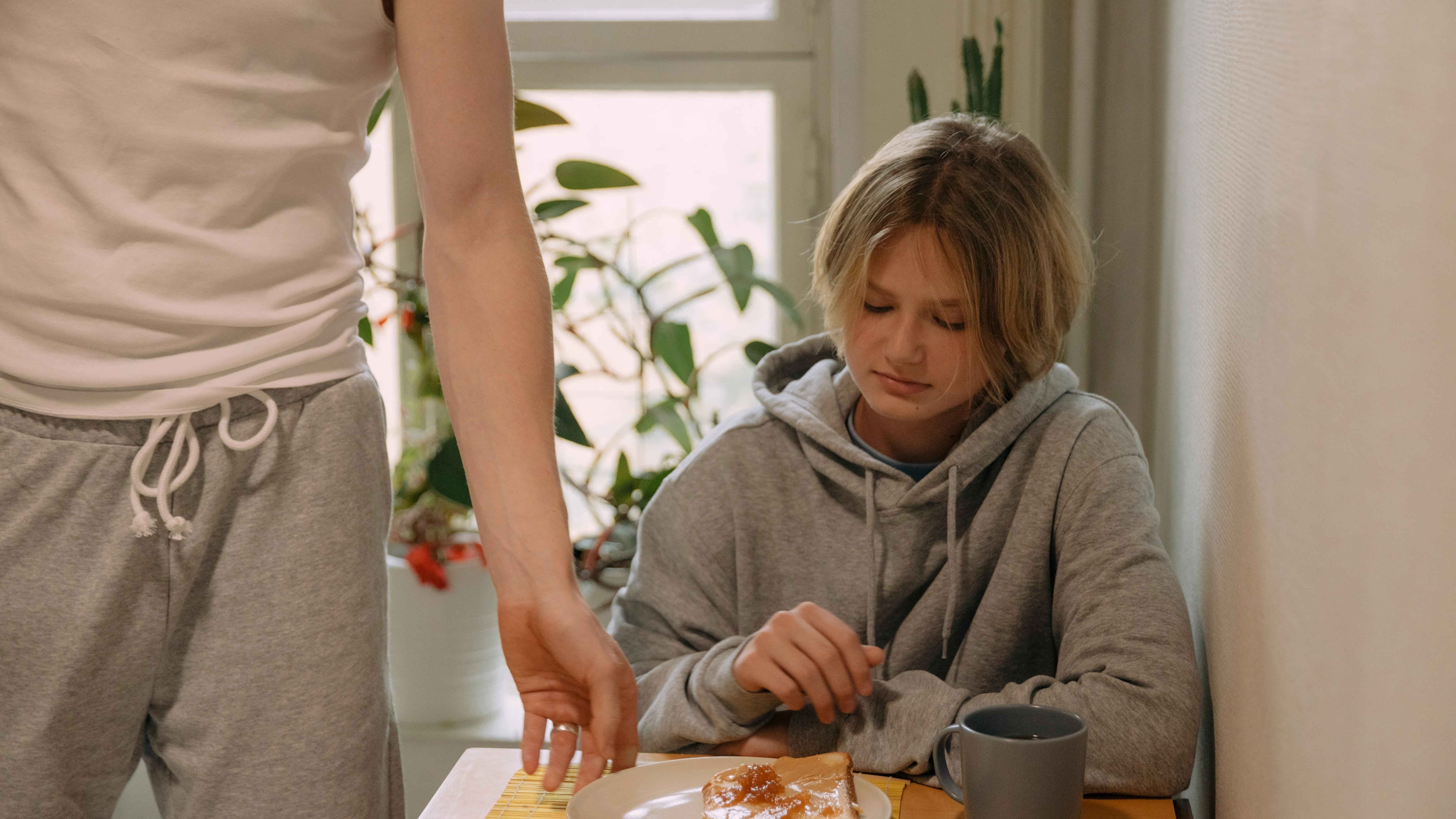 Una chica se muestra contrariada mientras desayuna una tostada