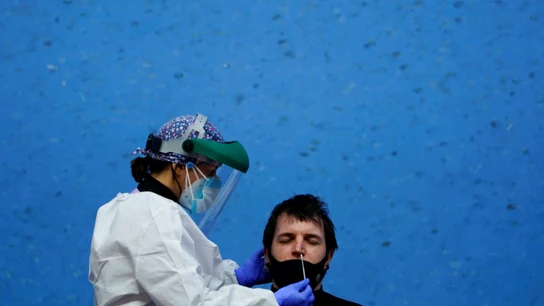 Una sanitaria realiza una prueba PCR a un paciente Una sanitaria realiza una prueba PCR a un paciente