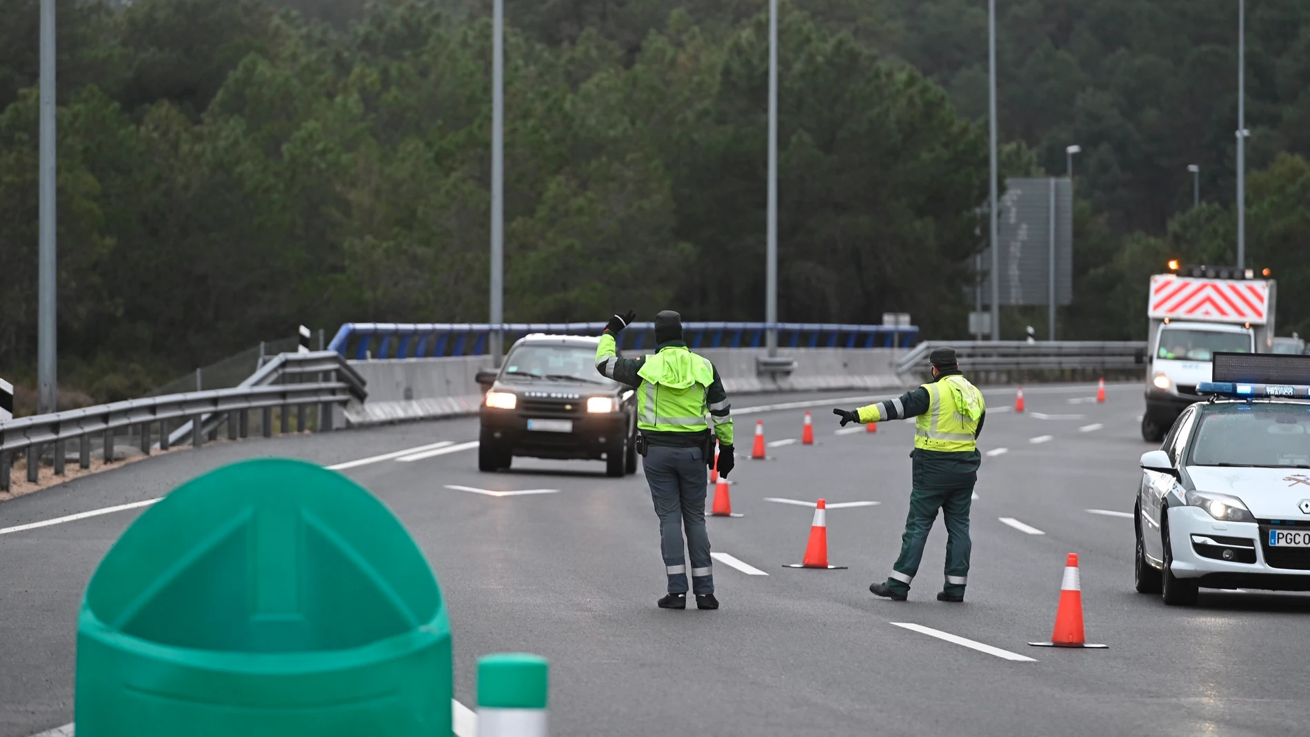 Varios guardias civiles de tráfico dan el alto a un vehículo en un control de carretera