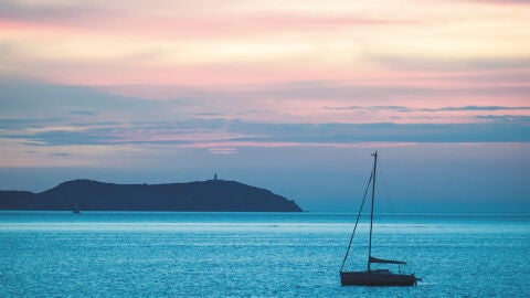 Atardecer con el faro de Sa Conillera al fondo