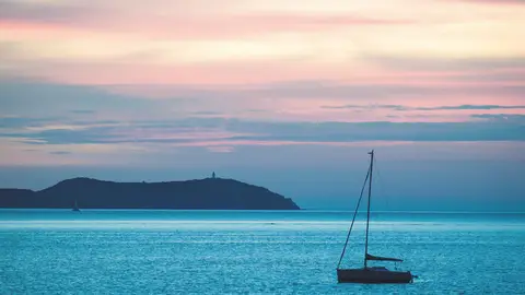 Atardecer con el faro de Sa Conillera al fondo Atardecer con el faro de Sa Conillera al fondo