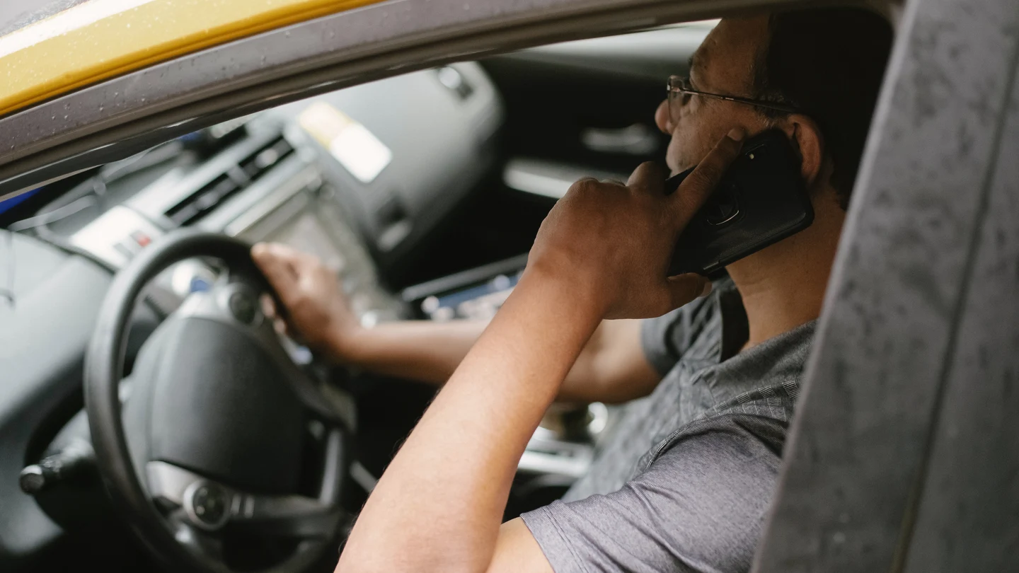 Un hombre habla por teléfono mientras conduce Un hombre habla por teléfono mientras conduce