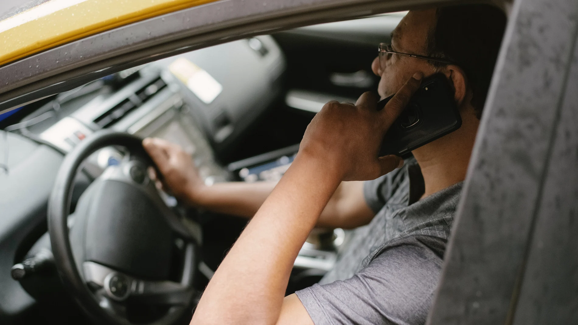 Un hombre habla por teléfono mientras conduce